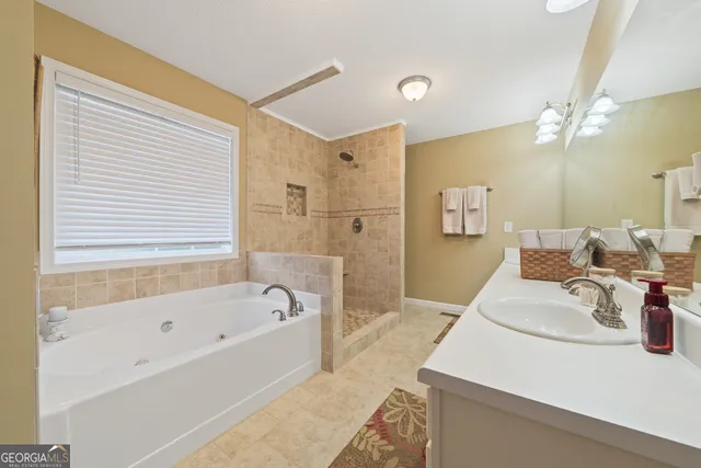 a bathroom with a tub sink and mirror