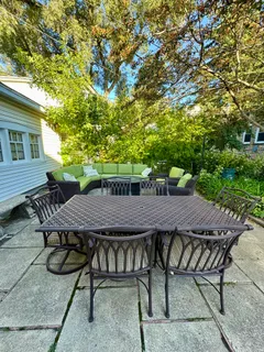 a backyard of a house with table and chairs