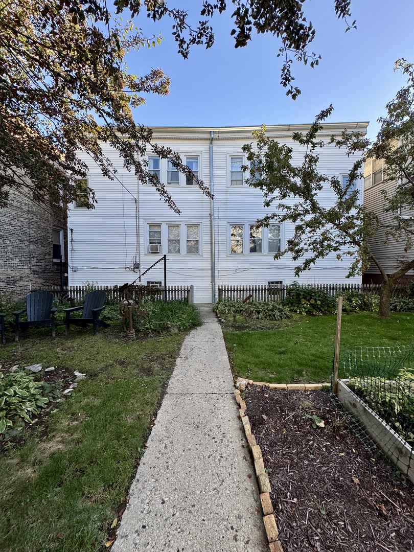 2604 West Winona Street, Unit 2W Chicago, IL 60625 - Photo 6 of 7 a view of a white house next to a yard with big trees