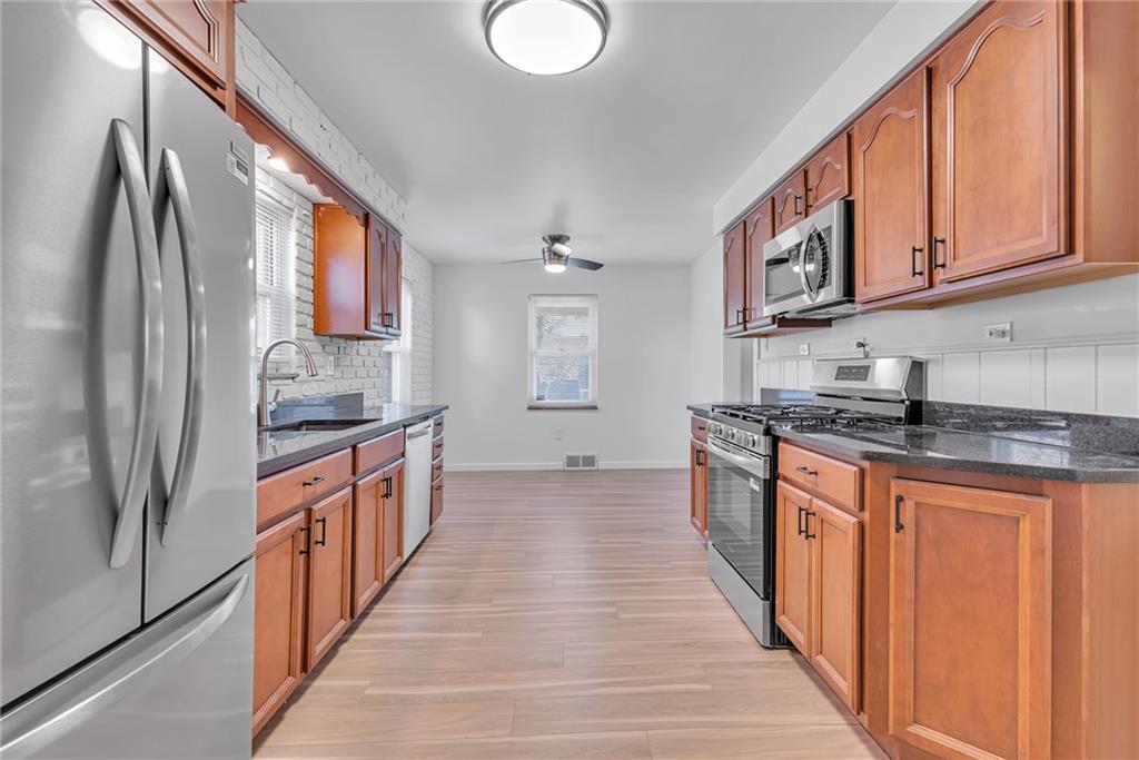 1526 Elgin Street Aliquippa, PA 15001 - Photo 3 of 33 a large kitchen with stainless steel appliances granite countertop a refrigerator and a stove top oven
