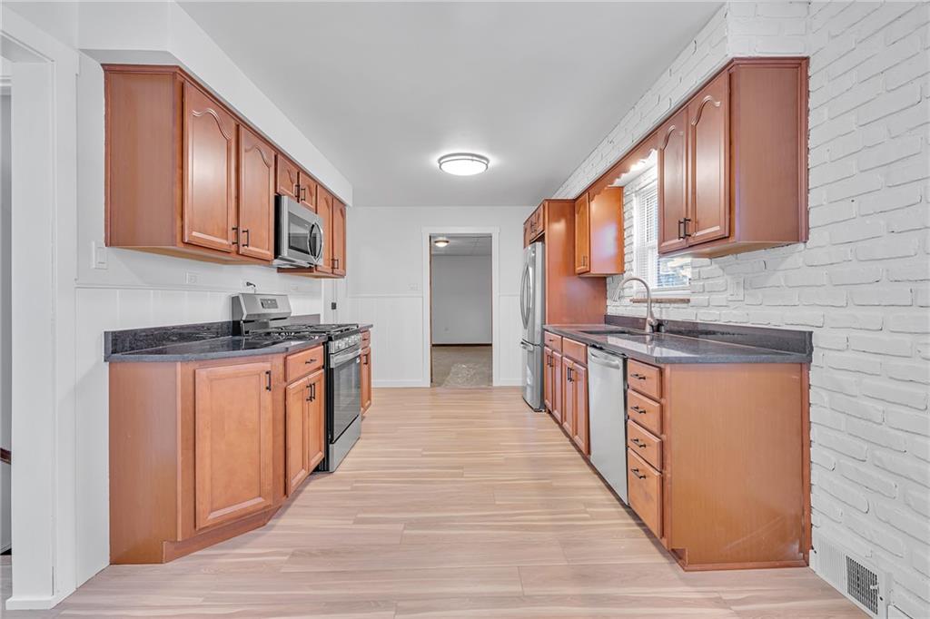 1526 Elgin Street Aliquippa, PA 15001 - Photo 32 of 33 a large kitchen with stainless steel appliances granite countertop a stove a sink dishwasher and a refrigerator