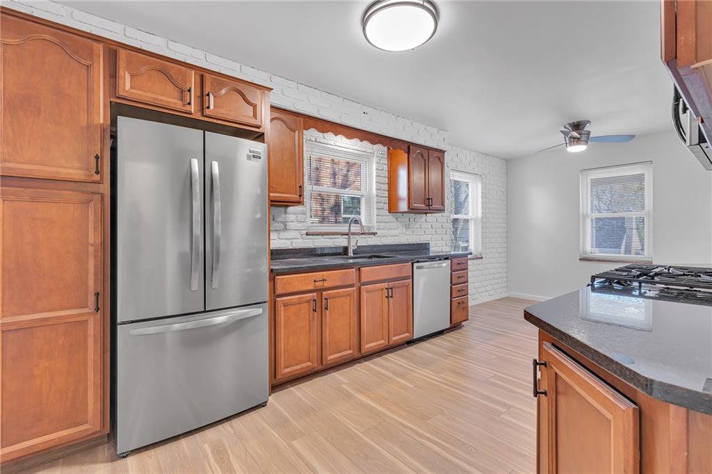 1526 Elgin Street Aliquippa, PA 15001 - Photo 4 of 33 a kitchen with stainless steel appliances granite countertop a refrigerator a sink dishwasher a stove with wooden cabinets and floors