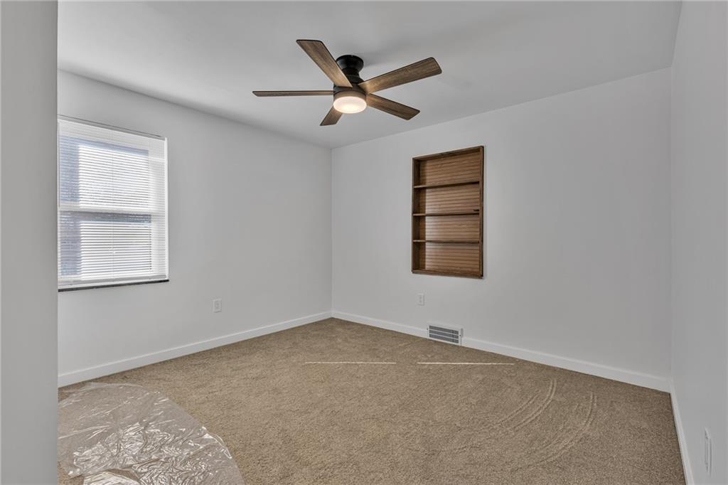 1526 Elgin Street Aliquippa, PA 15001 - Photo 10 of 33 an empty room with a ceiling fan and window