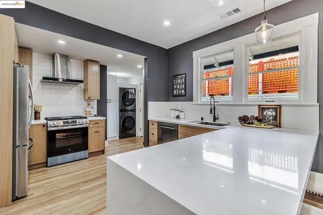 a large kitchen with stainless steel appliances granite countertop a stove a sink and a refrigerator