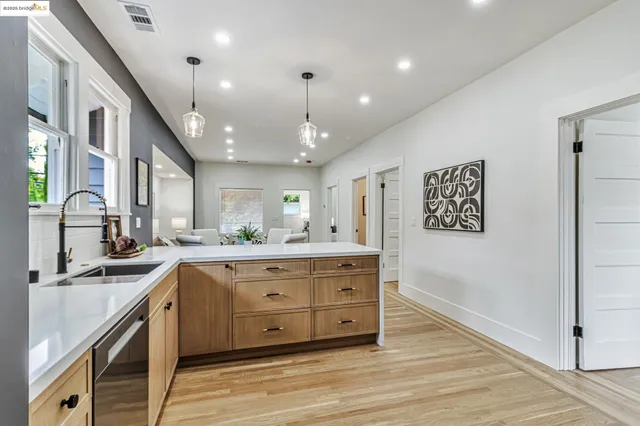 a large kitchen with a lot of counter space and wooden floor