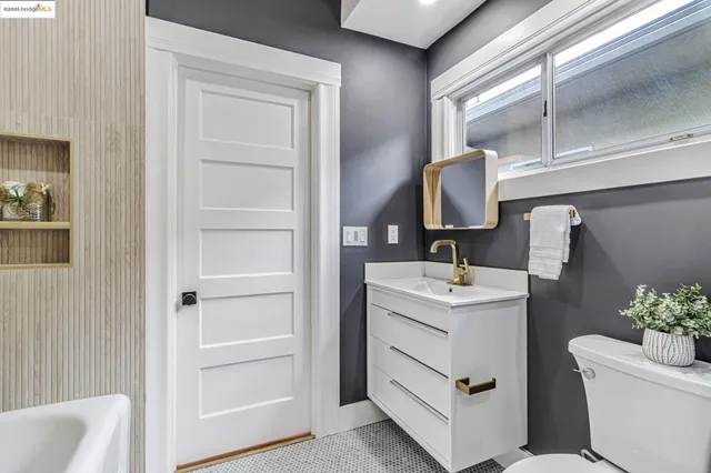 a bathroom with a sink toilet vanity and tub