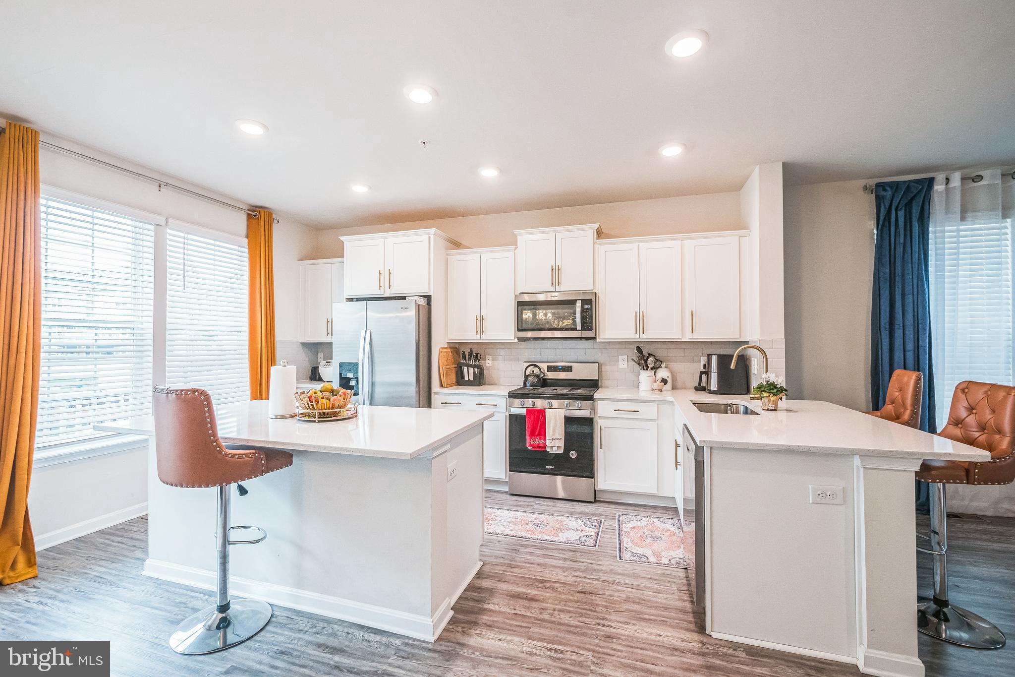 7041 Freedom Way Frederick, MD 21703 - Photo 3 of 32 a kitchen with stainless steel appliances kitchen island wooden cabinets a stove a refrigerator and a refrigerator