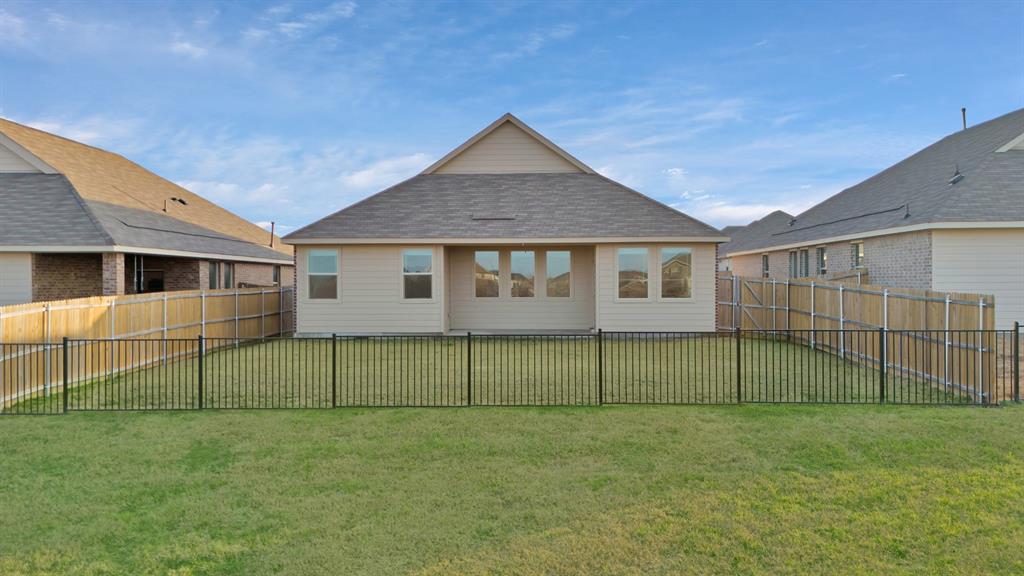 3204 Renaissance Drive Denton, TX 76207 - Photo 24 of 25 Expansive green lawn featuring a full black metal fence