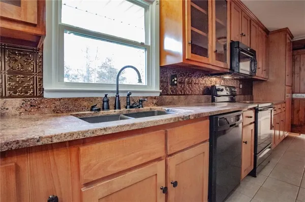 a kitchen with stainless steel appliances granite countertop a sink stove and cabinets