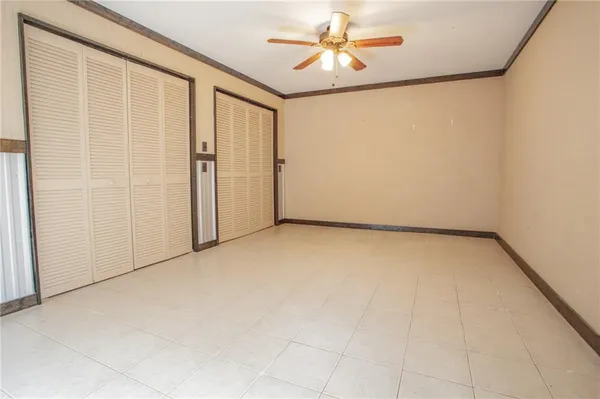 an empty room with a ceiling fan and a window