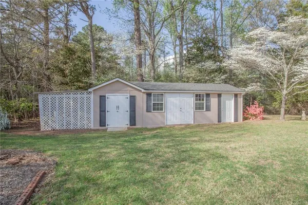 a view of a house with a yard and large tree