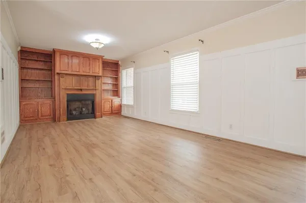 an empty room with fireplace and wooden floor