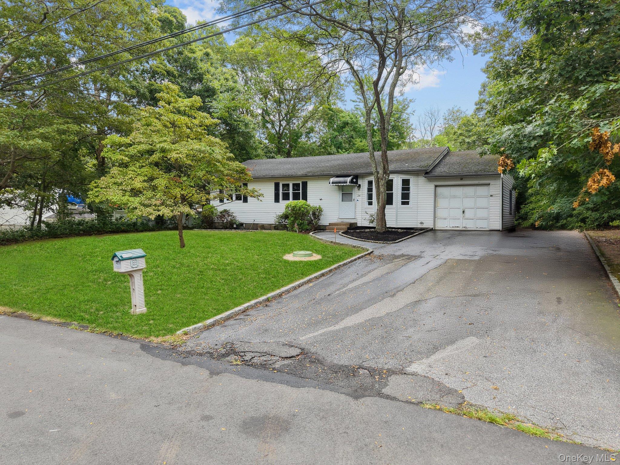 a front view of a house with a garden and trees