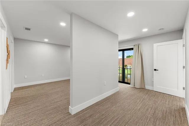 an empty room with wooden floor and entrance