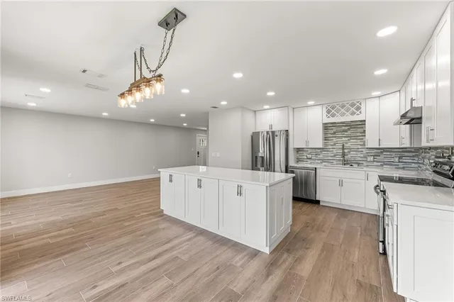 a kitchen with white cabinets and refrigerator