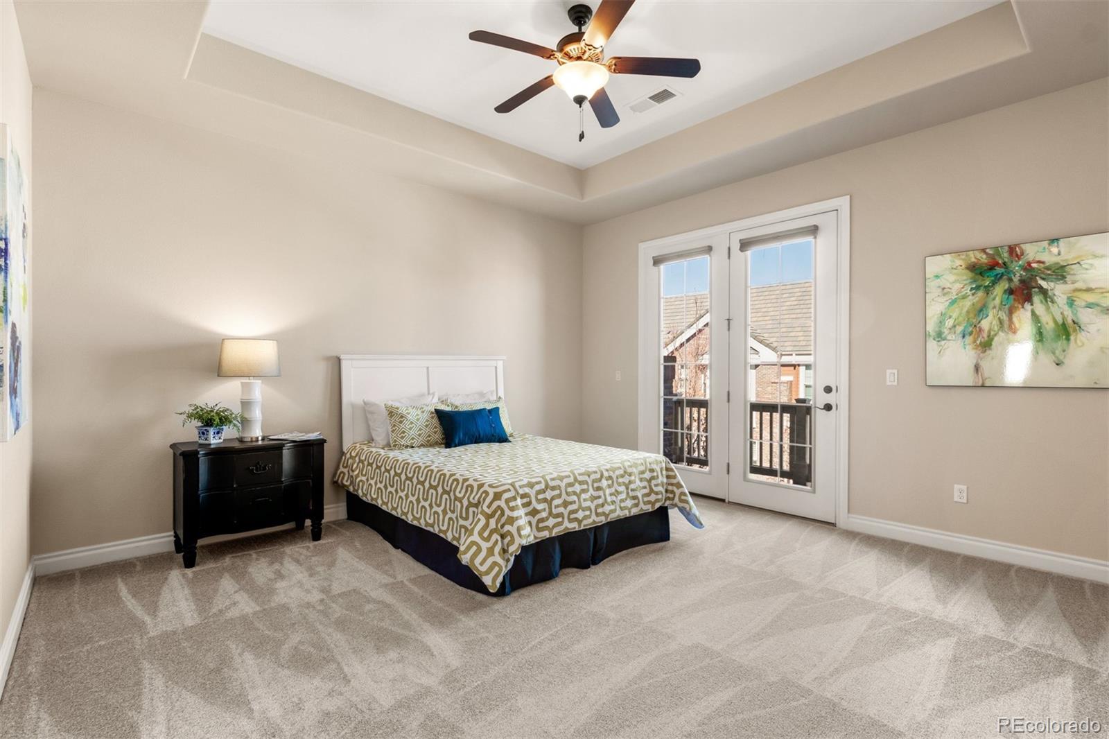 9256 Mornington Way Lone Tree, CO 80124 - Photo 19 of 36 a spacious bedroom with a bed and a chandelier
