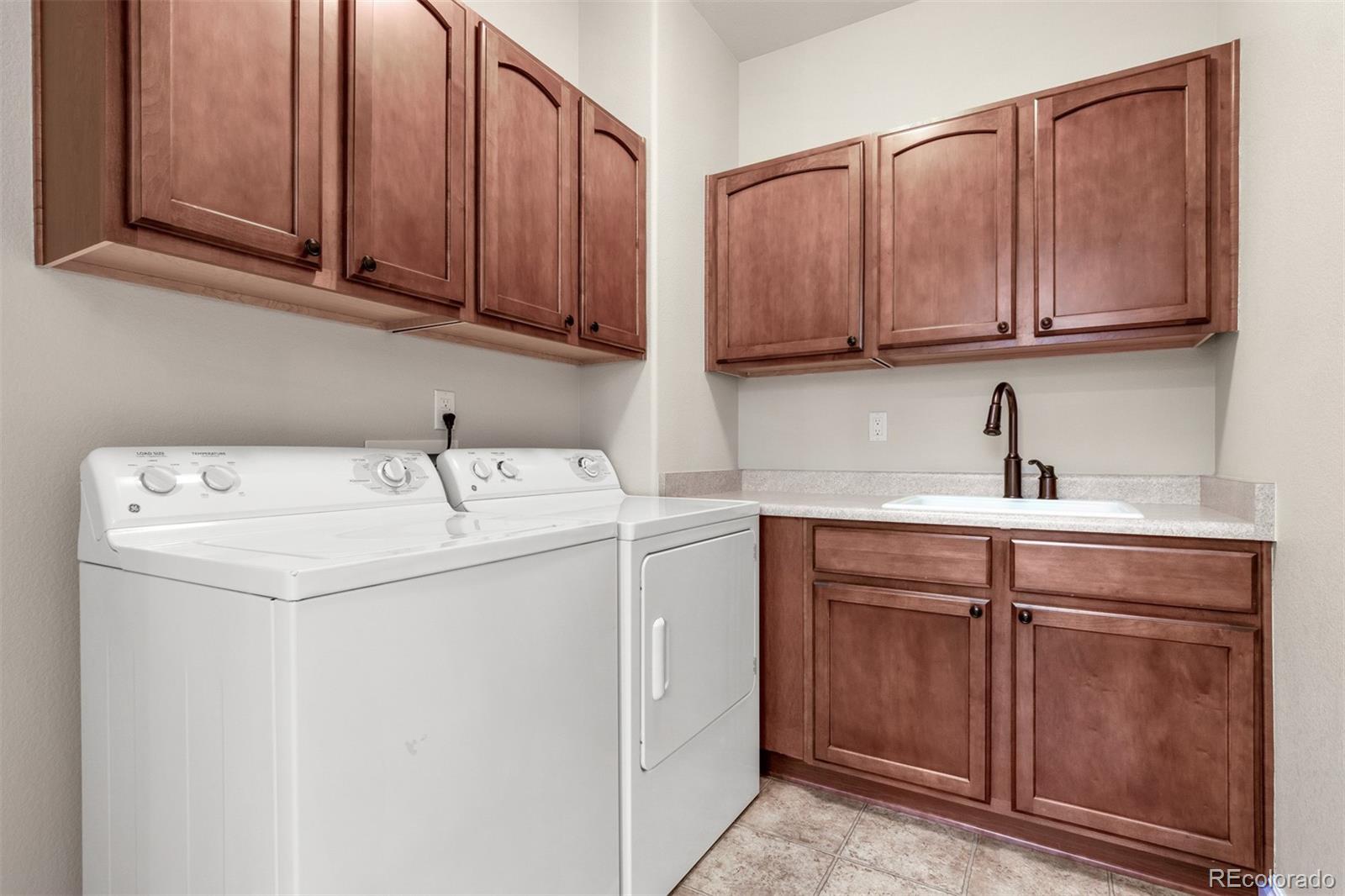 9256 Mornington Way Lone Tree, CO 80124 - Photo 29 of 36 a utility room with stainless steel appliances granite countertop a sink and cabinets