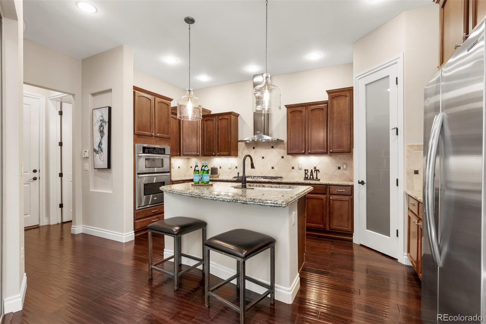 9256 Mornington Way Lone Tree, CO 80124 - Photo 9 of 36 a kitchen with stainless steel appliances kitchen island granite countertop a refrigerator and a stove top oven