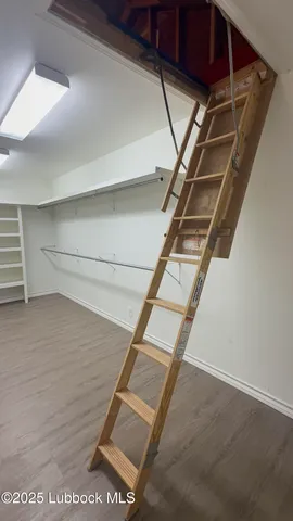 a view of a room with wooden floor and door