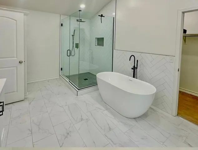 an empty room that has a window and a chandelier fan