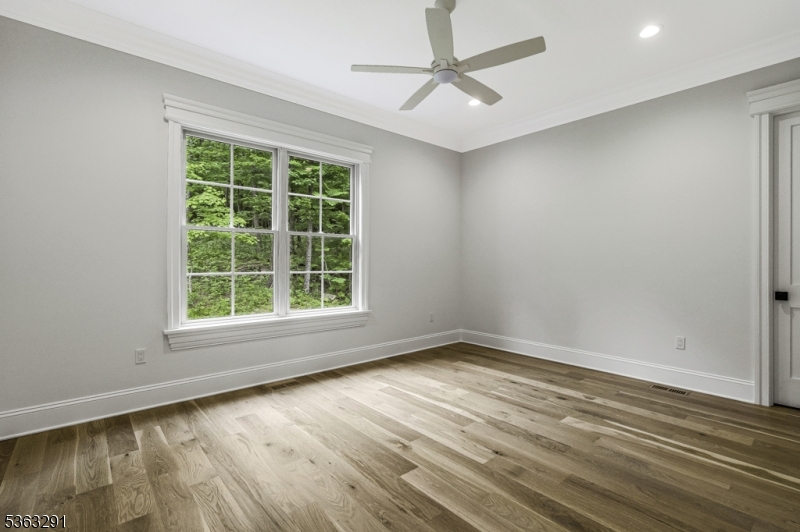 8 Cobblestone Court Warren, NJ 07059 - Photo 32 of 50 an empty room with wooden floor fan and windows
