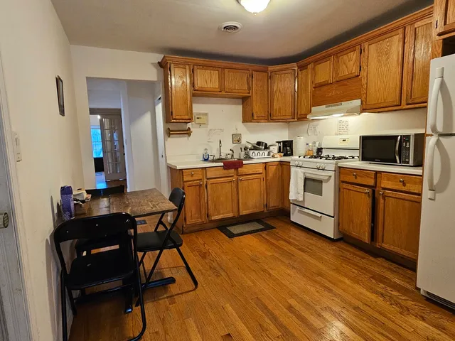 a kitchen with a table chairs microwave and cabinets
