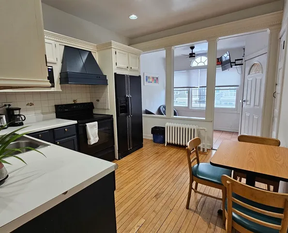 a kitchen with a table chairs and refrigerator