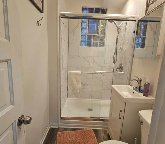 a bathroom with a sink a toilet and shower