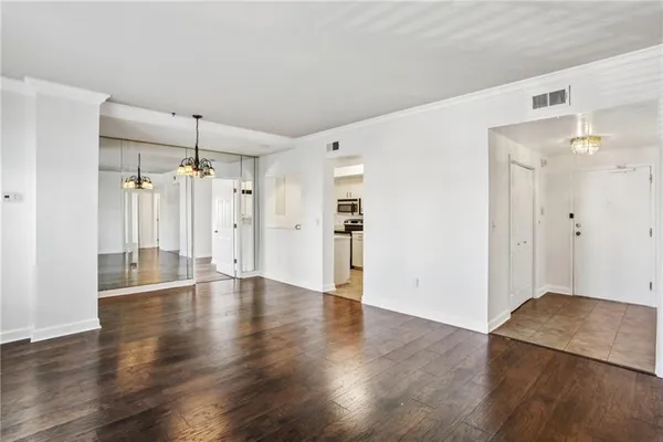 a view of an empty room with wooden floor