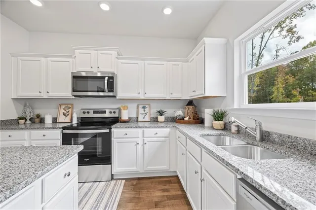 a kitchen with stainless steel appliances granite countertop a sink stove microwave and cabinets