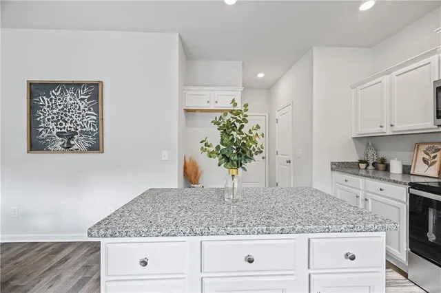 a view of kitchen with granite countertop stove top oven sink and cabinets