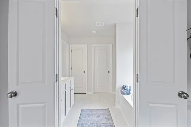 a view of a hallway with white doors