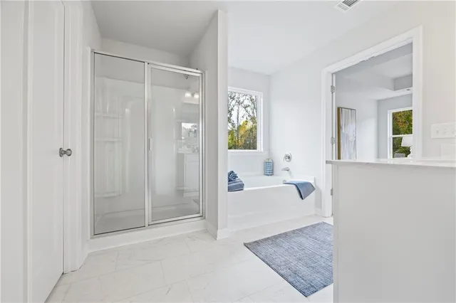 a spacious bathroom with a tub shower and mirror