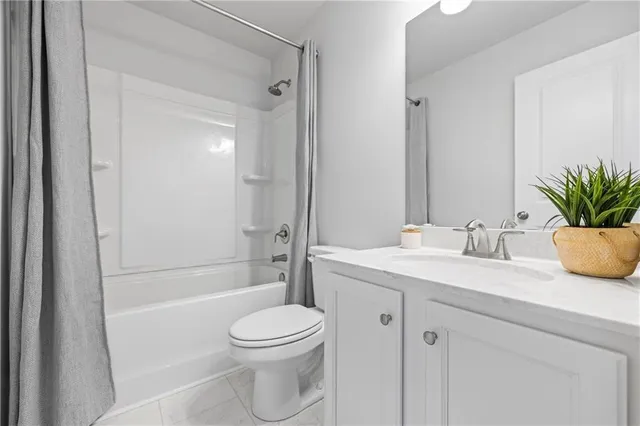 a bathroom with a granite countertop sink a toilet and tub