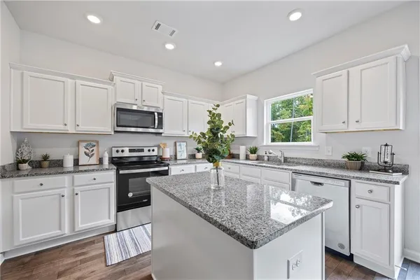a kitchen with stainless steel appliances granite countertop a sink stove microwave and cabinets