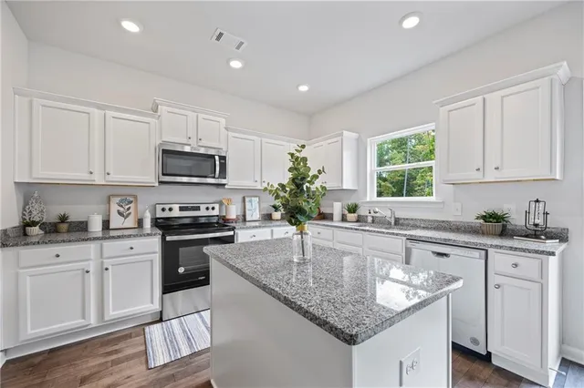 a kitchen with stainless steel appliances granite countertop a sink stove microwave and cabinets