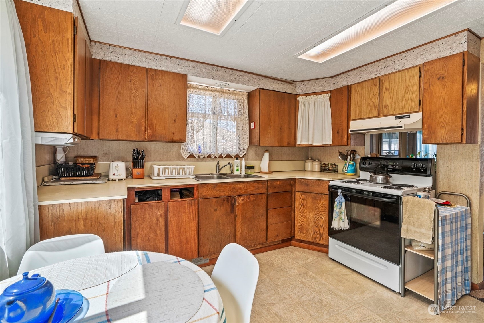 502 Burcham Street Kelso, WA 98626 - Photo 17 of 38 a kitchen with stainless steel appliances granite countertop a stove a sink dishwasher a microwave oven with a dining table and chair