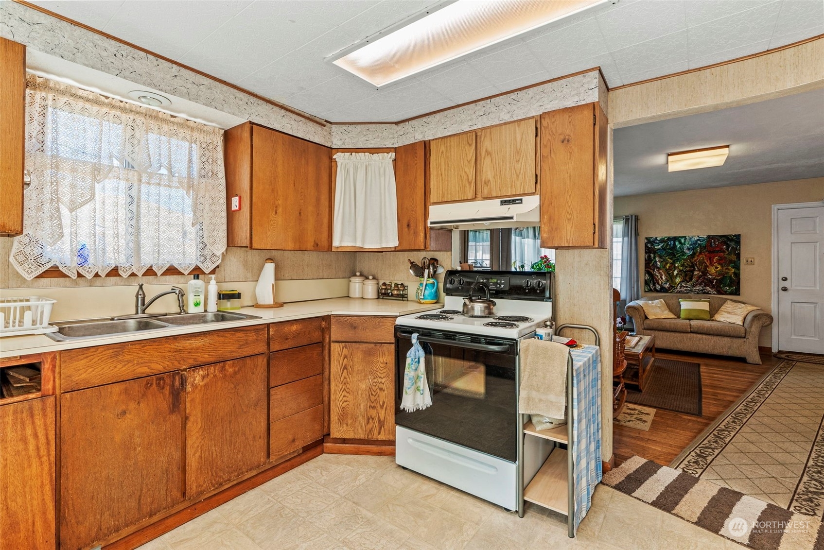 502 Burcham Street Kelso, WA 98626 - Photo 18 of 38 a kitchen with stainless steel appliances granite countertop a stove top oven a sink dishwasher a dining table and chairs with wooden floor