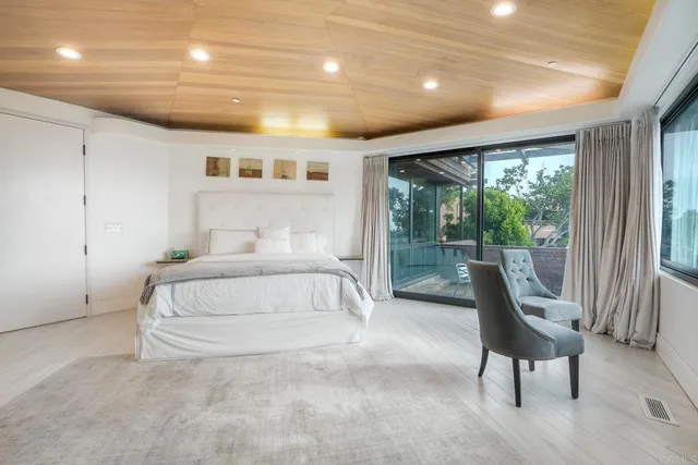 a spacious bedroom with a large bed and a view of chair