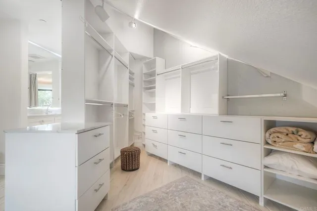 a kitchen with white cabinets and window
