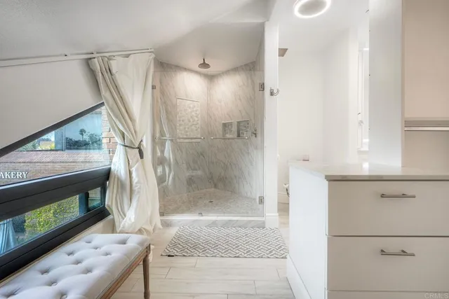 a bathroom with a tub shower vanity and a sink