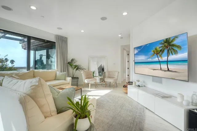 a living room with furniture a floor to ceiling window and a flat screen tv
