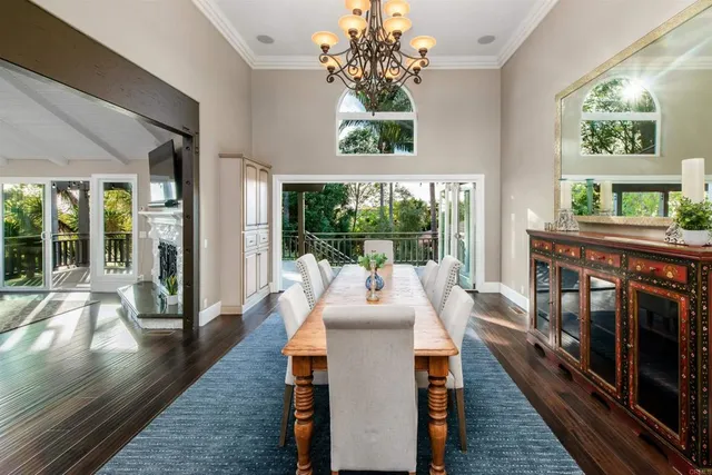 a kitchen with stainless steel appliances granite countertop a stove a refrigerator a kitchen island a sink dishwasher a dining table and chairs with wooden floor