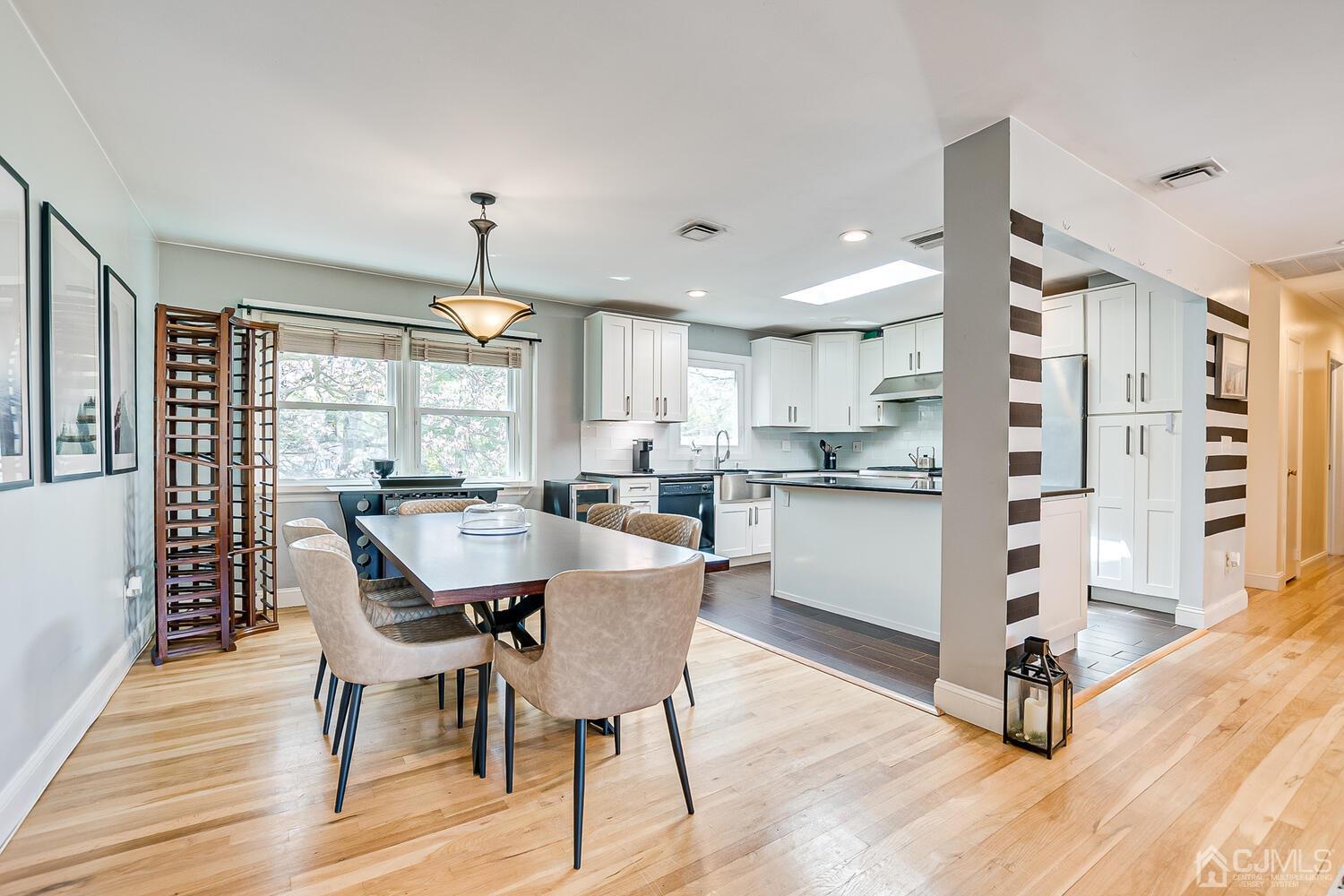 20 Homestead Road Metuchen, NJ 08840 - Photo 15 of 49 a dining room with kitchen island granite countertop a table chairs a sink dishwasher window and cabinets
