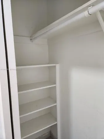 a view of walk in closet with empty racks