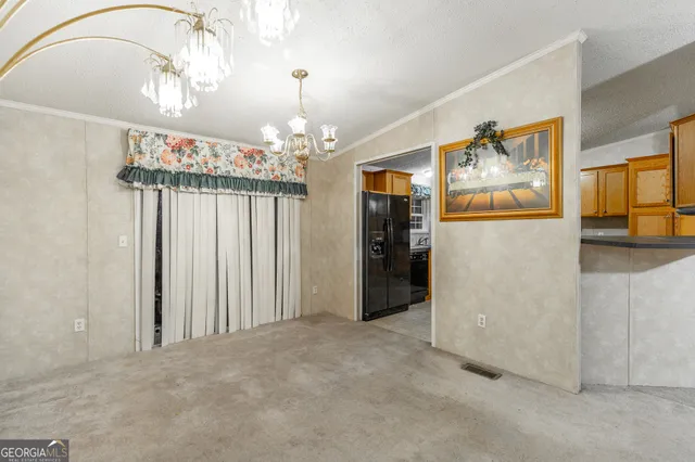 a view of a hallway with a dining table chairs and a chandelier