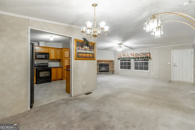 a view of a livingroom with a chandelier a kitchen space with a chandelier