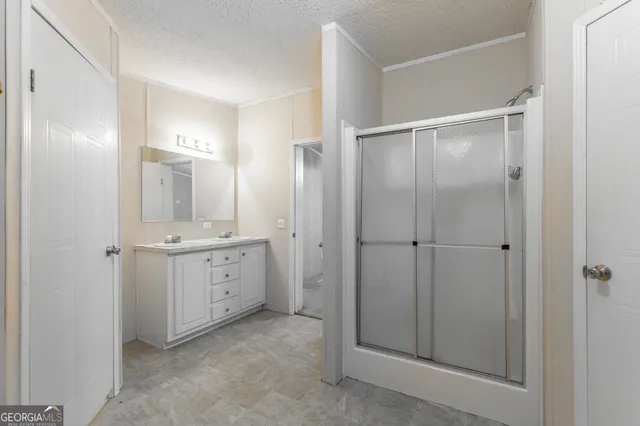 a bathroom with a double vanity sink mirror and shower