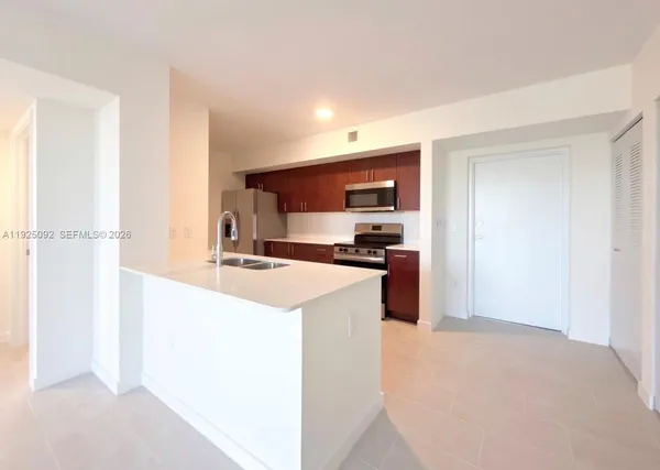 a kitchen with a refrigerator and a stove top oven