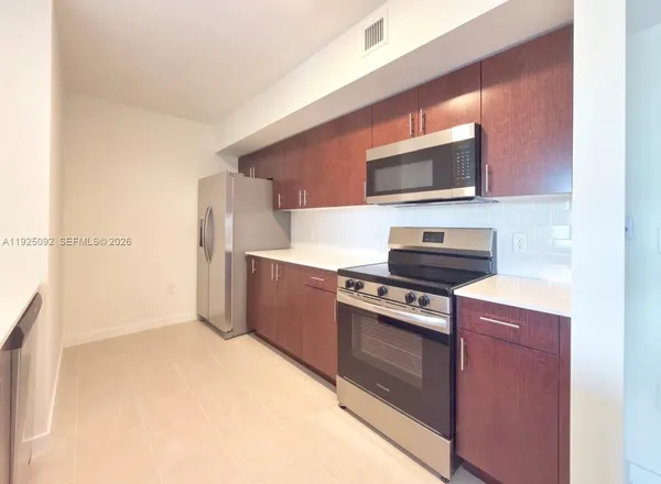 a kitchen with stainless steel appliances a stove a microwave and a refrigerator